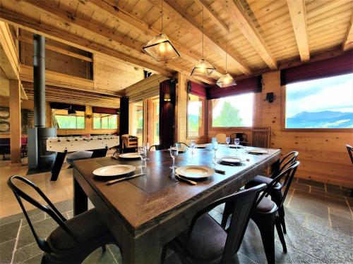 une salle à manger avec une grande table et des chaises en bois dans l'établissement Chalet Les Sauvageons - Grand luxe au cœur des Gets, avec piscine & hammam MAE-2431, aux Gets