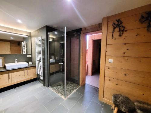 une salle de bain avec douche et lavabo dans l'établissement Chalet Les Sauvageons - Grand luxe au cœur des Gets, avec piscine & hammam MAE-2431, aux Gets