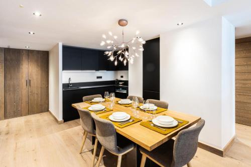 une salle à manger avec une table et des chaises en bois dans l'établissement Résidence Le Vieux ChÊne - Appartement chic 