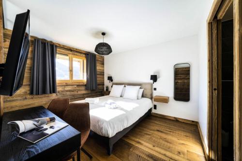 une chambre avec un lit, une table et un bureau dans l'établissement Résidence Grand Theatre - Appartement de très beau standing, belle exposition, proche centre MAE-2451, aux Gets