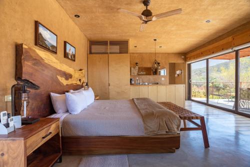 a bedroom with a large bed and a large window at Mexico en la Piel in Valle de Guadalupe