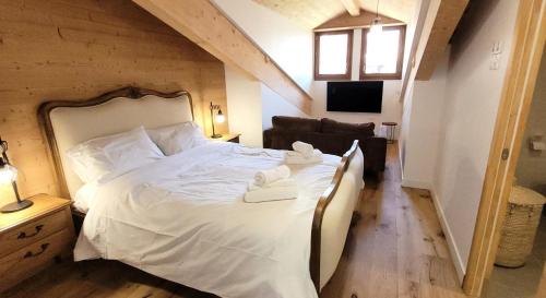 une chambre avec un grand lit avec des draps blancs dans l'établissement Résidence Cottage Alpin - Magnifique appartement 8 personnes, au calme, proche pistes des Perrières MAE-2471, aux Gets