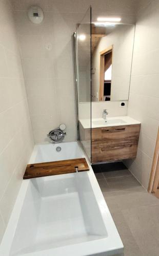 une salle de bain avec une baignoire, un lavabo et un miroir dans l'établissement Résidence Cottage Alpin - Magnifique appartement 8 personnes, au calme, proche pistes des Perrières MAE-2471, aux Gets