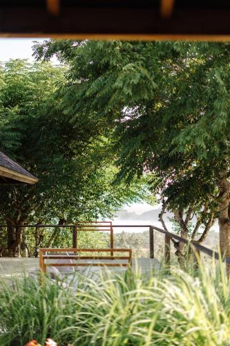 a wooden bench sitting in front of a tree at Villa Sorgas in Kuta Lombok