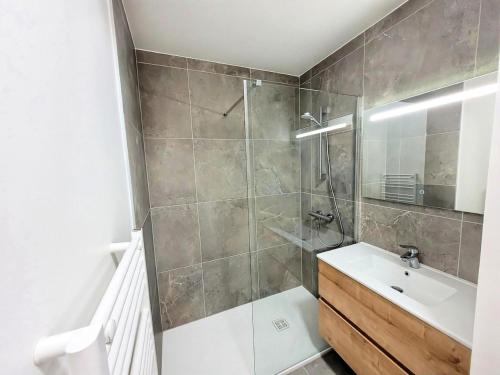 une salle de bain avec une douche avec un lavabo et un miroir dans l'établissement Résidence Carmine Lodge - Très bel appartement en duplex, 3 chambres + cabine MAE-2491, aux Gets