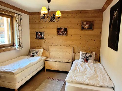 deux lits dans une chambre aux murs en bois dans l'établissement Résidence Mont Chery - Appartement tres lumineux, beaux volumes, haut standing MAE-2501, aux Gets