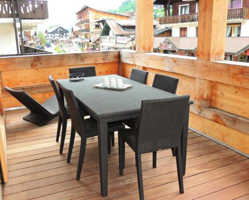 une table noire et des chaises sur un balcon dans l'établissement Résidence Mont Chery - Appartement tres lumineux, beaux volumes, haut standing MAE-2501, aux Gets