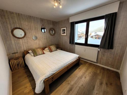 une chambre avec un lit et une grande fenêtre dans l'établissement Résidence Le Vorzay - Appartement Cosy 4 Ambiance 