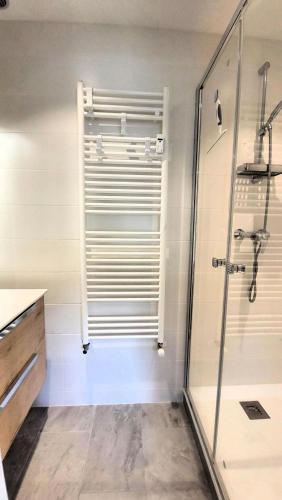 une salle de bain avec douche et porte vitrée dans l'établissement Résidence Helios - Appartement de belle capacité, au calme, proximité centre MAE-2521, aux Gets