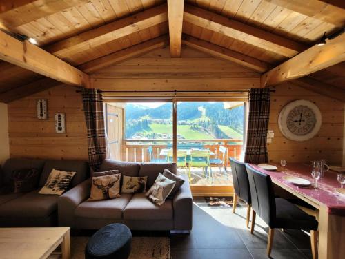 un salon avec un canapé et une table dans l'établissement Chalets Chantemerle - Chalet en surplomb du village, idéal pour famille MAE-2541, aux Gets