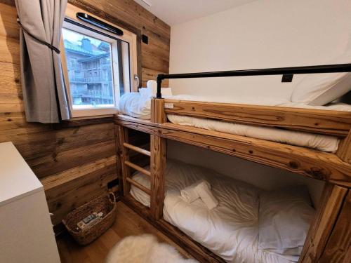 deux lits superposés dans une chambre avec fenêtre dans l'établissement Résidence Essentiel - Appartement de standing, esprit cosy, large terrasse MAE-2531, aux Gets