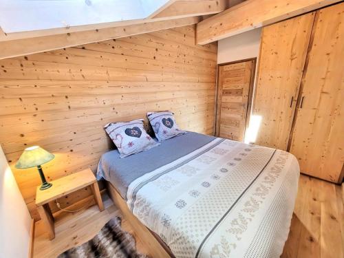 une chambre avec un lit dans une cabane en bois dans l'établissement Résidence Le Hameau Des Cornuts - Appartement lumineux secteur Perrieres MAE-2551, aux Gets