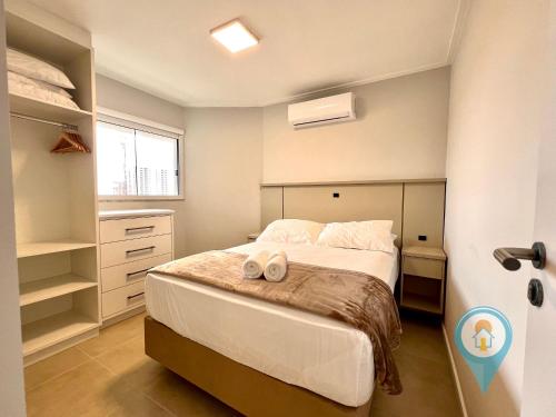 a bedroom with a bed with two towels on it at Aconchegante apartamento a 3 min. do Beto Carrero e Praia in São Lídio