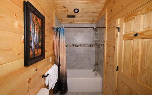 a bathroom with a white tub and a shower at A Splash of Heaven in Pigeon Forge