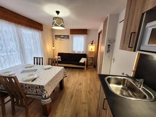 une cuisine et un salon avec une table et un évier dans l'établissement Résidence Chanteneige - Appartement 4 personnes proche du centre MAE-2611, aux Gets