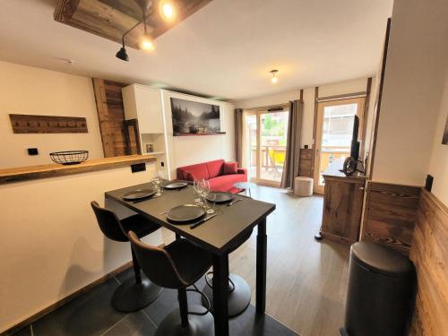 une salle à manger avec une table et des chaises dans une pièce dans l'établissement Résidence Le Confidentiel - Appartement neuf, capacité 4 personnes, au centre MAE-2631, aux Gets