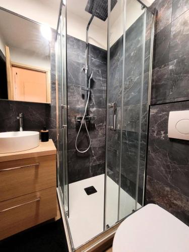 une salle de bain avec une douche avec des toilettes et un lavabo dans l'établissement Résidence Le Nabor - Appartement 4 personnes plein centre MAE-2641, aux Gets