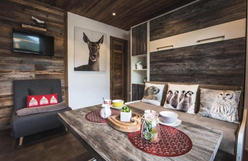- un salon avec une table en bois et une chaise dans l'établissement Résidence Ranfolly - Studio au centre du village MAE-2651, aux Gets