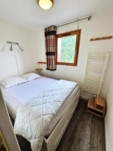 une chambre avec un grand lit avec une fenêtre dans l'établissement Résidence Grand Argentier - 3 pièces +cabine 8 /10personnes coeur station 55m² MAE-7171, à Modane