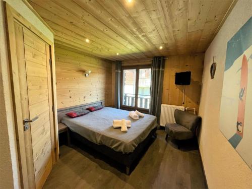une petite chambre avec un lit et une chaise dans l'établissement Résidence Beau Sejour - Bel appartement rénové, spacieux, lumineux, balcon exposé Sud Ouest MAE-7381, aux Gets