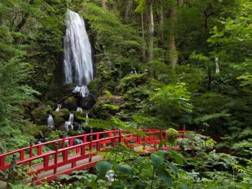 a red bridge in front of a waterfall at 湯河原 Hama no ie in Yugawara