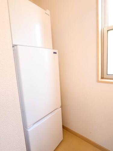 a white refrigerator in a room with a window at 湯河原 Hama no ie in Yugawara