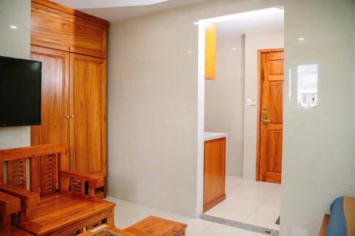 a living room with a television and wooden cabinets at Dragon Hotel & Apartments Đà Nẵng in Da Nang
