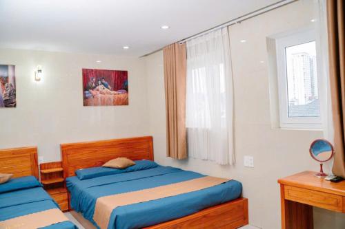 a bedroom with two beds and a window at Dragon Hotel & Apartments Đà Nẵng in Da Nang