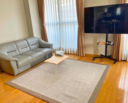 a living room with a couch and a coffee table at The Global West in Niihama