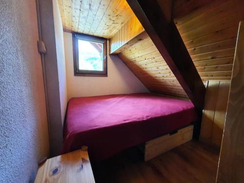 Cette petite chambre dispose d'un lit rouge dans un escalier. dans l'établissement Résidence Mas Du Peyron - Appartement lumineux · Accès piste par navette · Casier à skis privatif MAE-8394, à Saint-Chaffrey