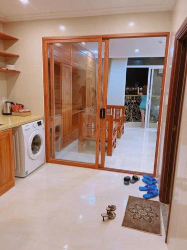 a kitchen with a washing machine and some shoes on the floor at Dragon Hotel & Apartments Đà Nẵng in Da Nang