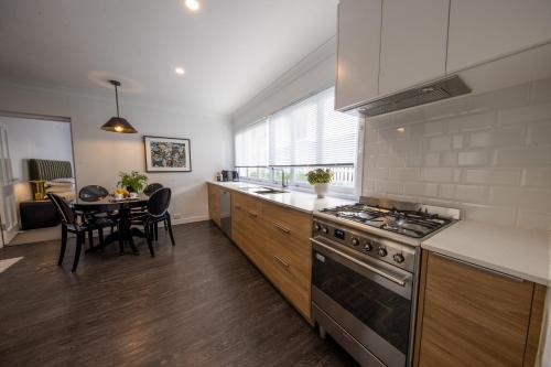 a kitchen with a stove top oven next to a table at Heal House in Brisbane