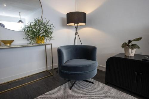 a blue chair in a living room with a lamp at Heal House in Brisbane