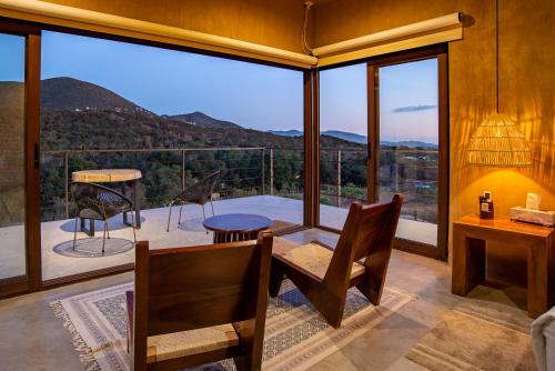 a room with a table and chairs and a large window at Mexico en la Piel in Valle de Guadalupe