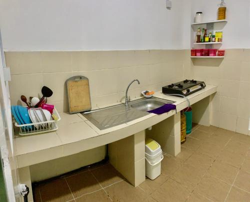 a kitchen counter with a sink and a stove at Ammar Homestay in Tawau