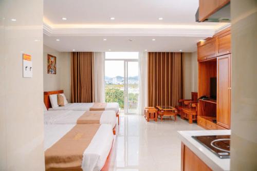 a hotel room with two beds and a desk at Dragon Hotel & Apartments Đà Nẵng in Da Nang