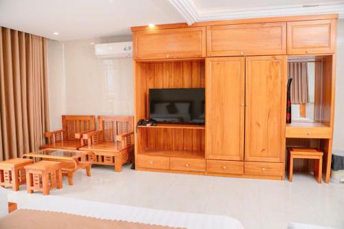a living room with a entertainment center with a television at Dragon Hotel & Apartments Đà Nẵng in Da Nang