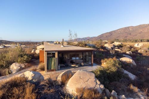 a house in the middle of a desert with rocks at Mexico en la Piel in Valle de Guadalupe