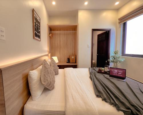 a bedroom with a large white bed and a window at L'amour Stay Dalat in Xuan An