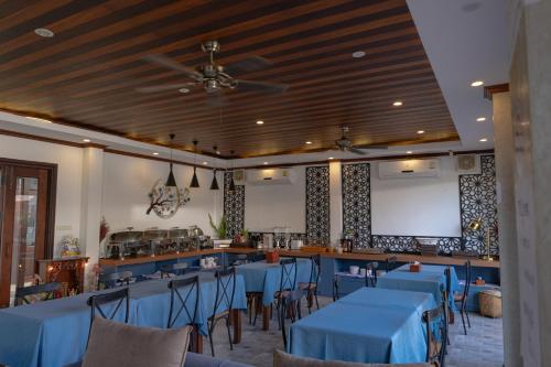 a restaurant with blue tables and chairs and a bar at Jasmine Luangprabang Hotel in Luang Prabang