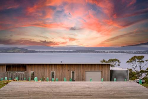 a building with a sunset in the background at The Outlook on Mount Louis - Stunning Views in Tinderbox
