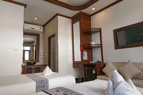 a hotel room with two beds and a tv at Jasmine Luangprabang Hotel in Luang Prabang