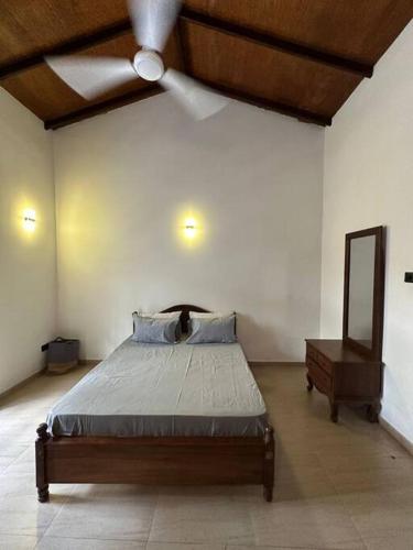 a bedroom with a bed and a ceiling fan at Spacious 3-Bedroom House in Colombo in Bokundara