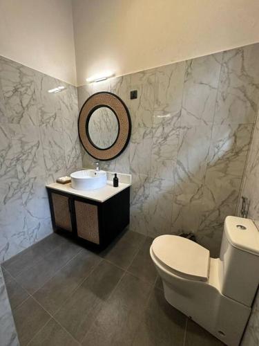 a bathroom with a sink and a toilet and a mirror at Spacious 3-Bedroom House in Colombo in Bokundara