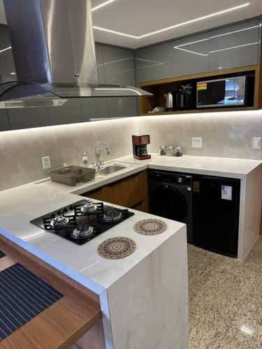 a kitchen with a stove and a counter top at Flat no Life Resort a Beira Lago in Brasilia