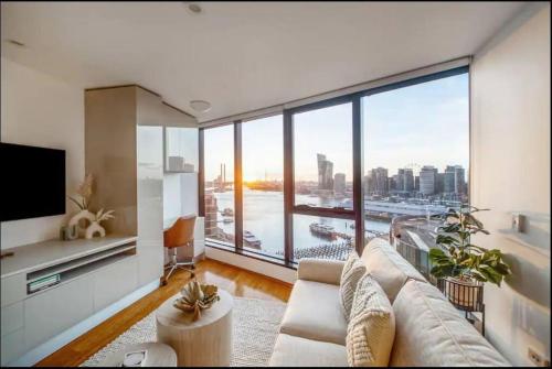 a living room with a couch and a large window at Breathtaking Harbour Views in Melbourne