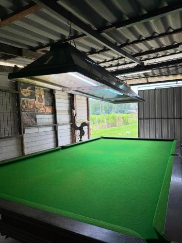 a pool table in a garage with a light above it at NP โฮมสเตย์ นอนเต็นท์ติดแอร์ in Ban Kaeng Manao