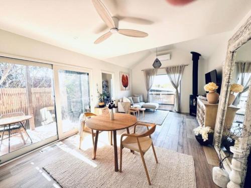 a living room with a table and chairs and a ceiling fan at Kalina Couples Coastal Escape in Blairgowrie