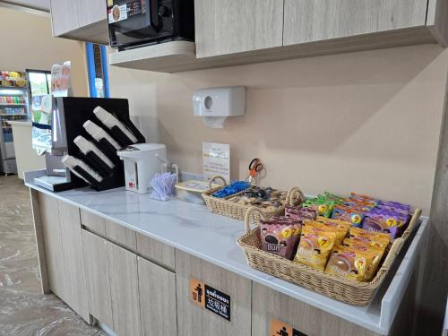 a counter with two baskets of chips and other snacks at One Budget Hotel Nan Pha Sing โรงแรม วัน บัดเจท น่าน ผาสิงห์ in Nan