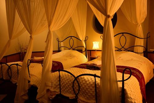 two beds in a bedroom with mosquito nets at Hotel Bali Moon in Toi